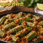 Bhindi Masala Recipe in Hindi – रेस्टोरेंट स्टाइल मसालेदार भिंडी मसाला सफेद बाउल में रोटी, प्याज और नींबू के साथ परोसा हुआ